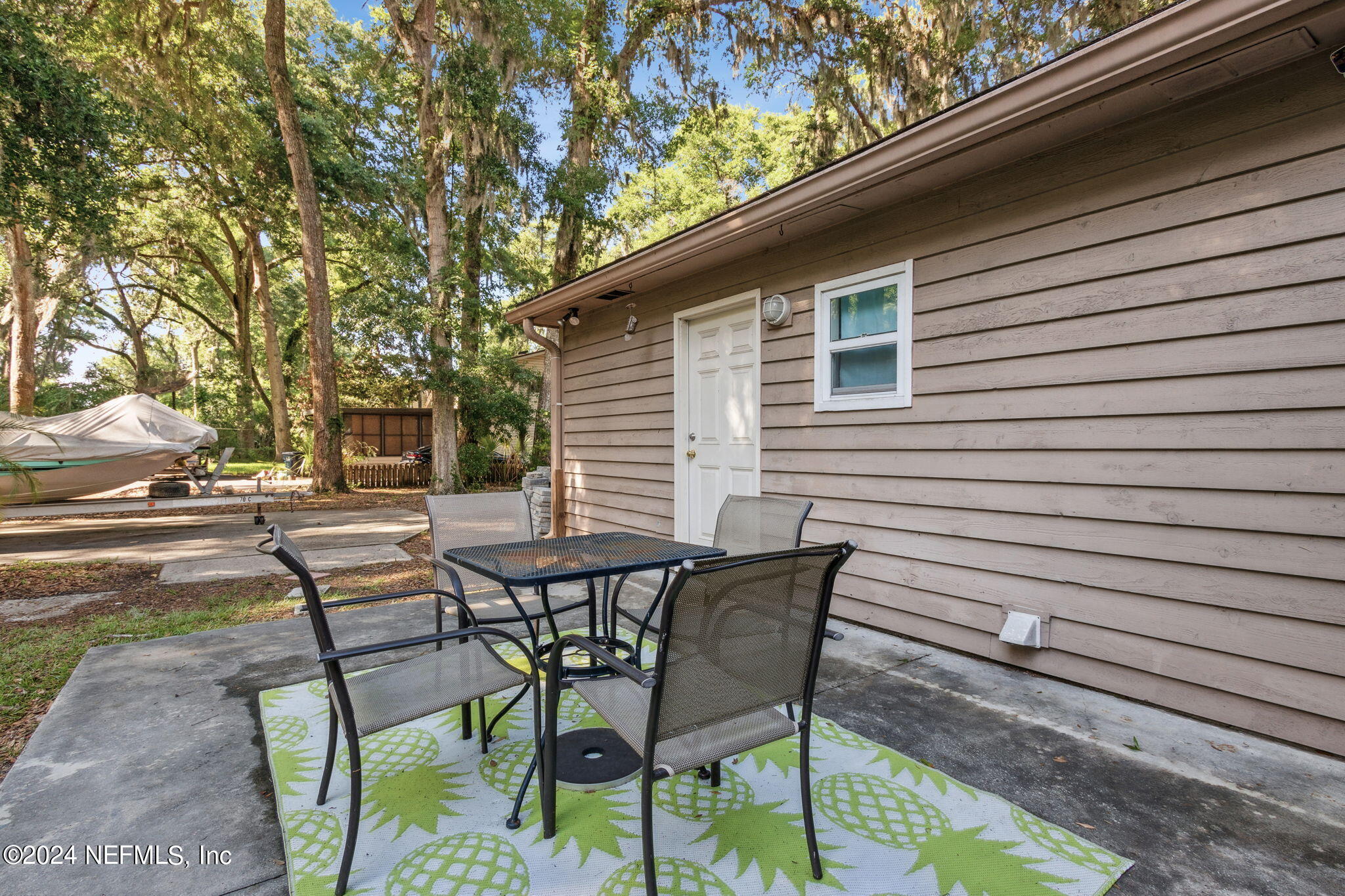 97125 Pirates Point Road Yulee, FL 32097 - Photo 49 of 90 a view of a patio with table and chairs and floor to ceiling window