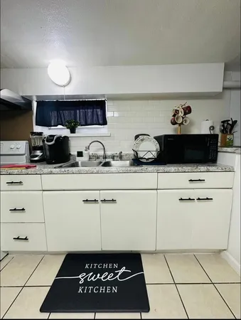 a kitchen with white cabinets a sink and white appliances