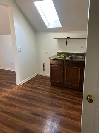 a kitchen with stainless steel appliances wooden floor and a sink