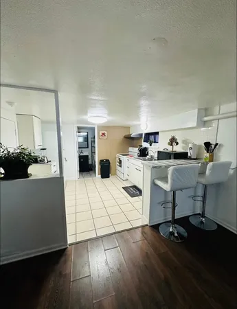 a living room with furniture and view of kitchen appliances