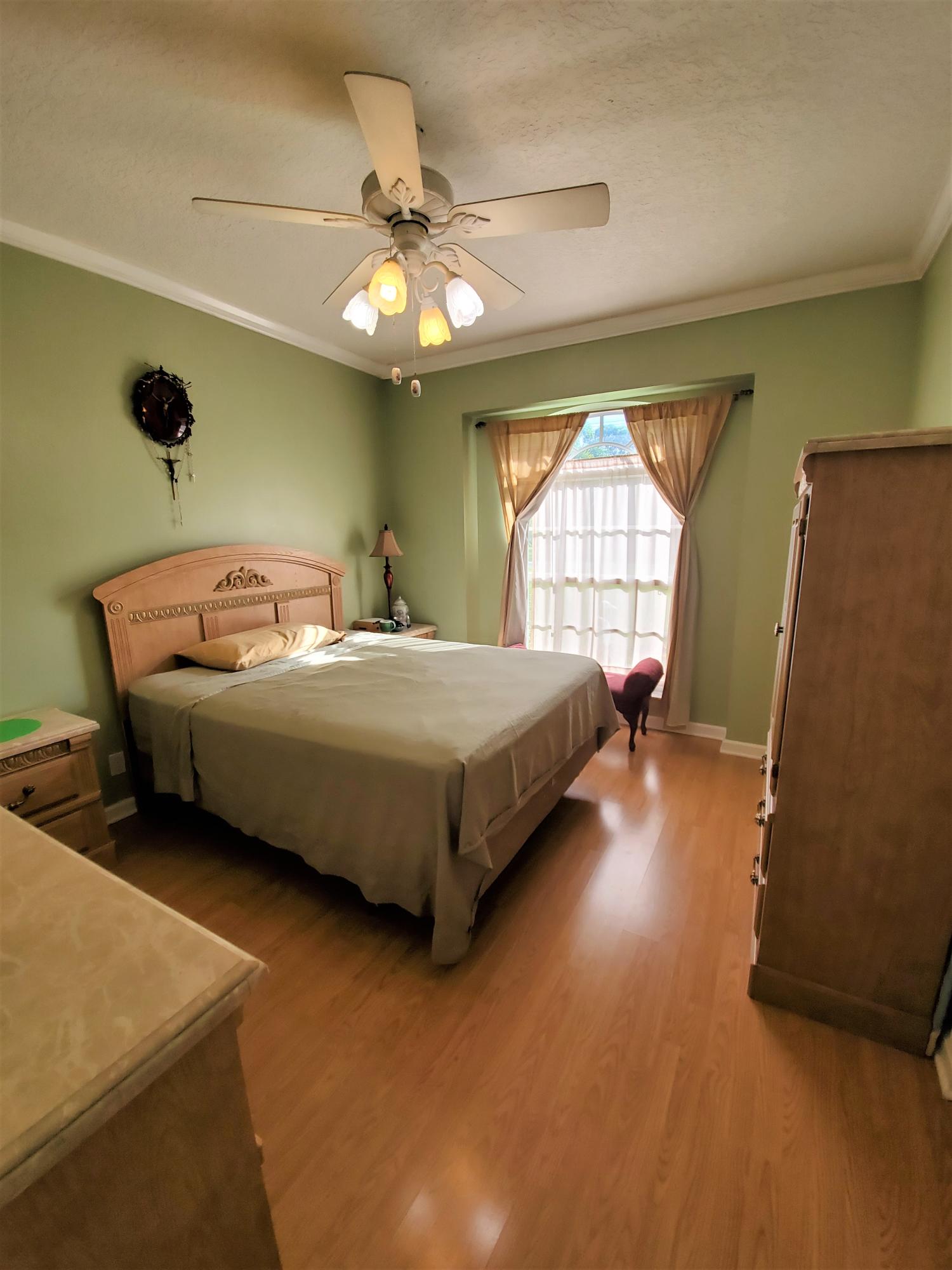 9897 Sandy Run Road Jupiter, FL 33478 - Photo 11 of 30 a bedroom with a bed and a chandelier