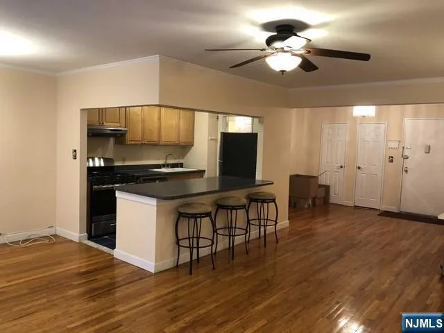 a kitchen with stainless steel appliances kitchen island hardwood floor and a sink