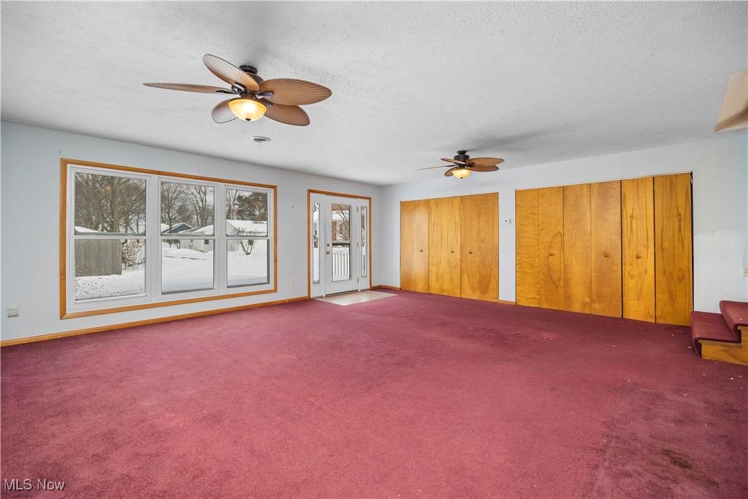 14015 West Lake Road Vermilion, OH 44089 - Photo 26 of 50 Unfurnished living room featuring a ceiling fan, carpet flooring, and a textured ceiling