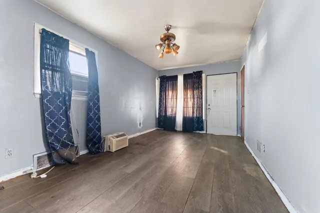 wooden floor in an empty room with a window