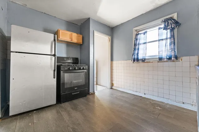 a kitchen with a refrigerator and a stove top oven