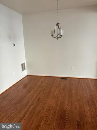a view of a room with wooden floor and white walls