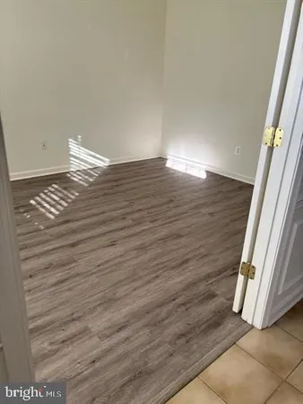 a view of a room with wooden floor and white walls