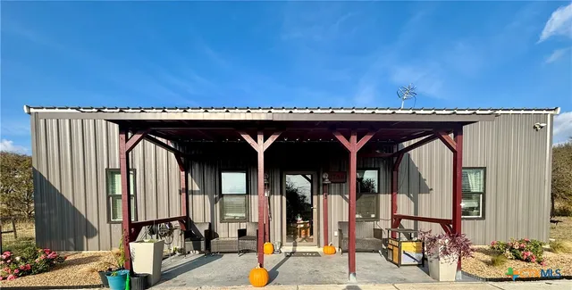 a view of a backyard with table and chairs and wooden fence