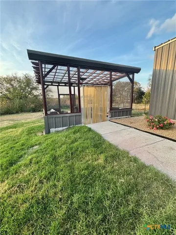 a view of a kitchen with kitchen island a counter top space a sink and wooden floor