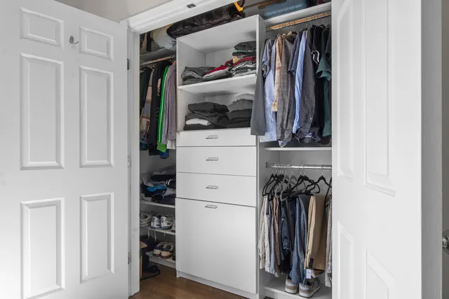 a view of walk in closet with clothes and shoes