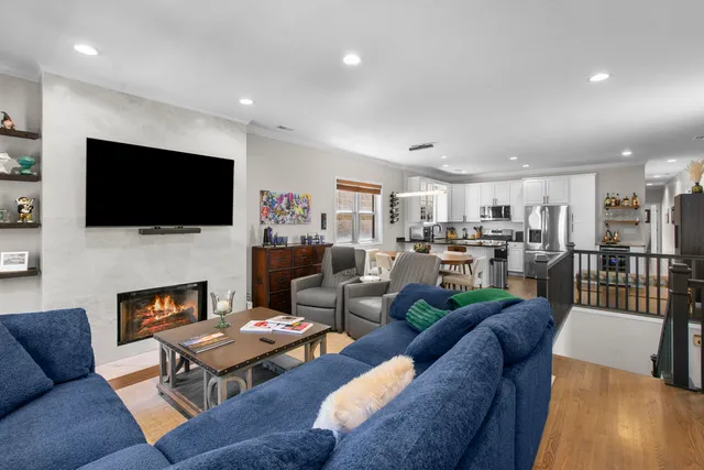 a living room with furniture a flat screen tv and kitchen view