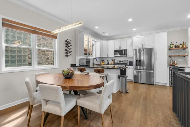 a kitchen with a dining table chairs and refrigerator