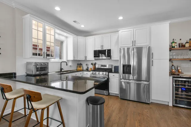 a kitchen with stainless steel appliances granite countertop a refrigerator and a stove top oven