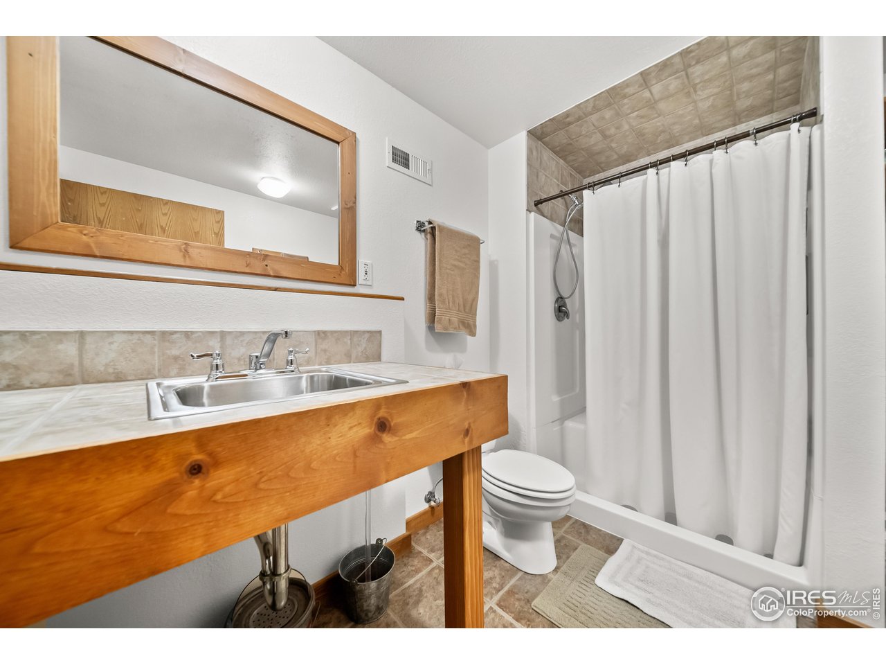 17680 County Rd Q.8 Fort Morgan, CO 80701 - Photo 21 of 40 a bathroom with a sink a toilet and a mirror
