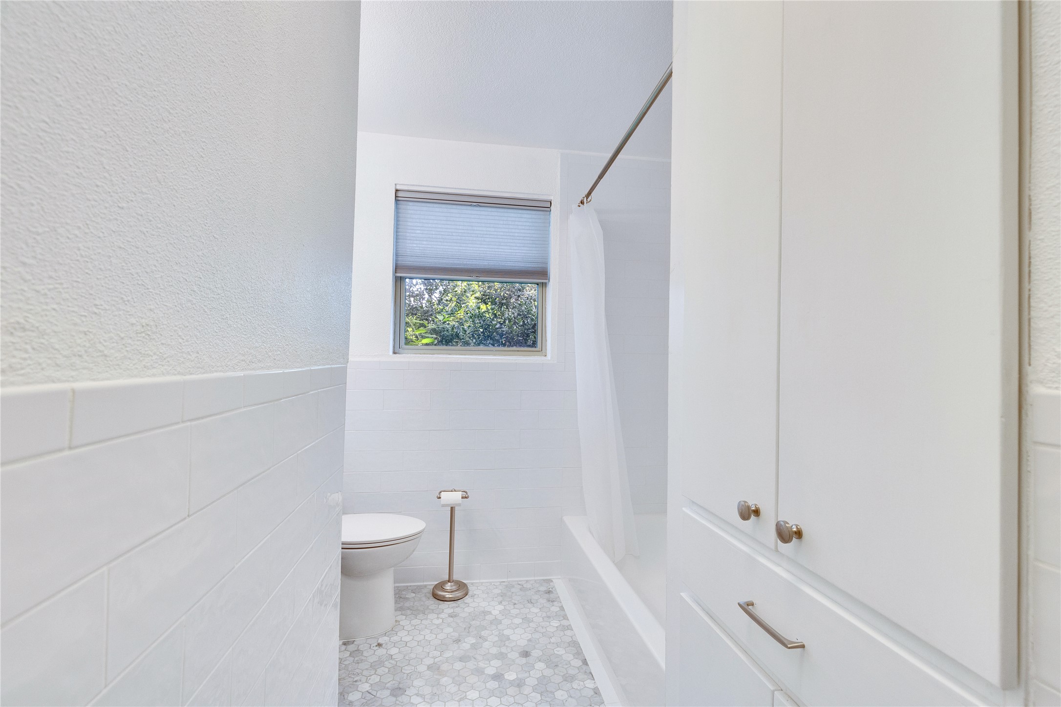 1306 Norwood Road, Unit A Austin, TX 78722 - Photo 16 of 21 A compact bathroom offers essential functionality with a toilet and integrated shower-tub combo.