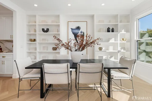 a kitchen with stainless steel appliances kitchen island a table and chairs in it