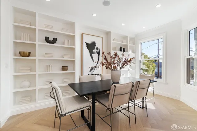 a living room with furniture kitchen area and a painting