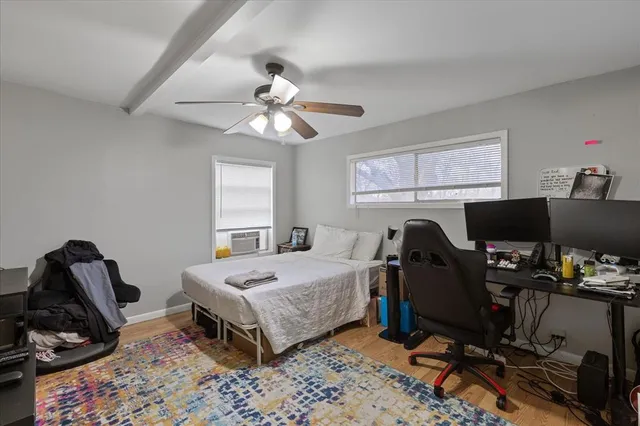 a bedroom that has a bed and a computer on a desk