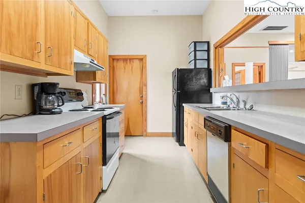 a kitchen with stainless steel appliances granite countertop a sink and a refrigerator