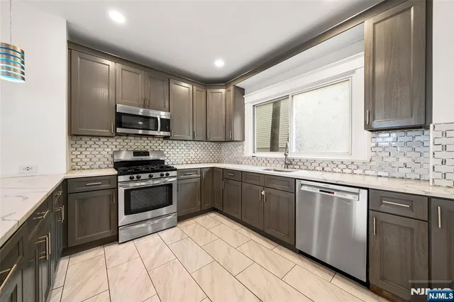 a kitchen with granite countertop cabinets stainless steel appliances and a sink