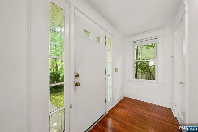 a view of an entryway with wooden floor and windows
