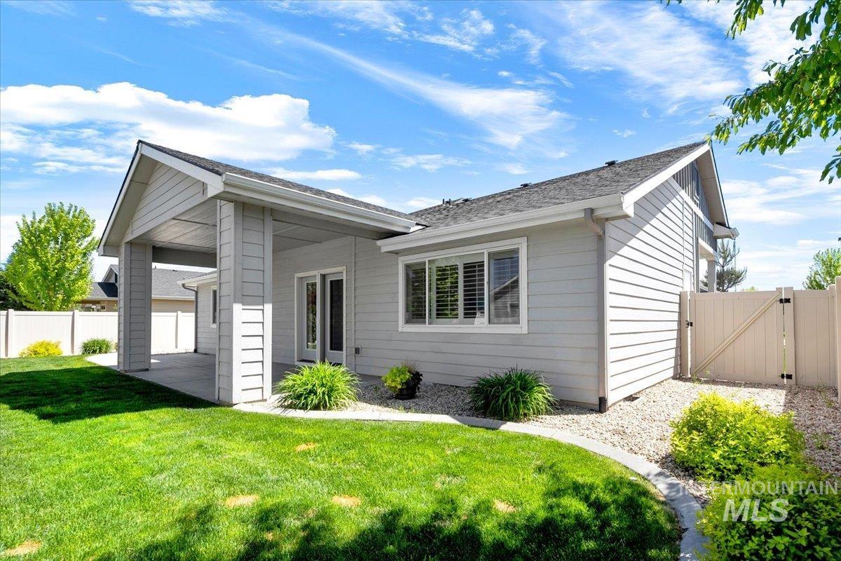 5850 West Rotherham Drive Eagle, ID 83616 - Photo 29 of 50 Private backyard featuring a well-maintained lawn, mature trees, and a concrete patio