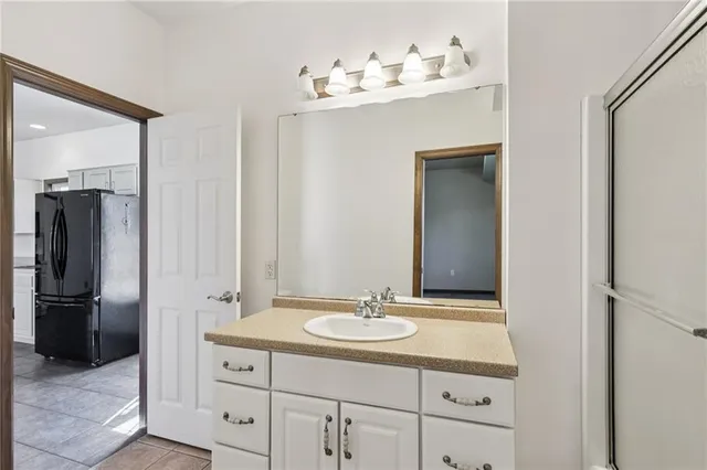 a bathroom with a granite countertop sink and white cabinets