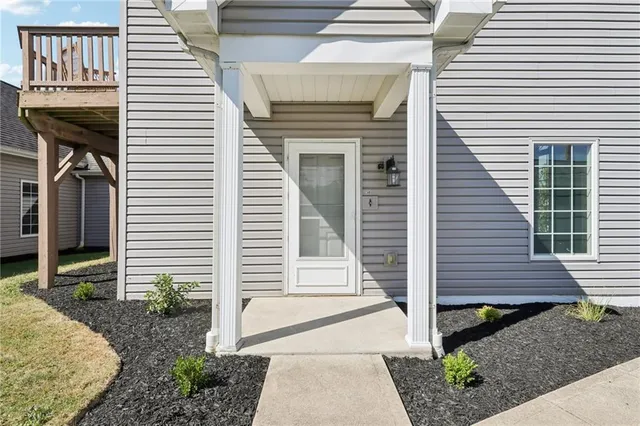a view of a house with a door and a large tree