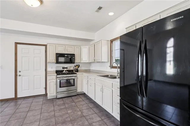 a view of a kitchen with a sink cabinets and a refrigerator