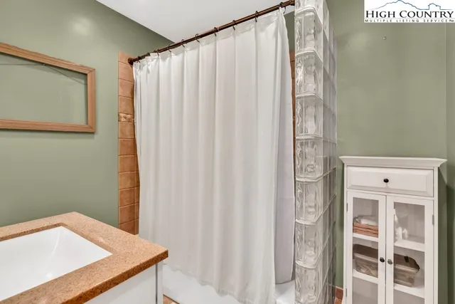 a bathroom with a shower curtain and sink