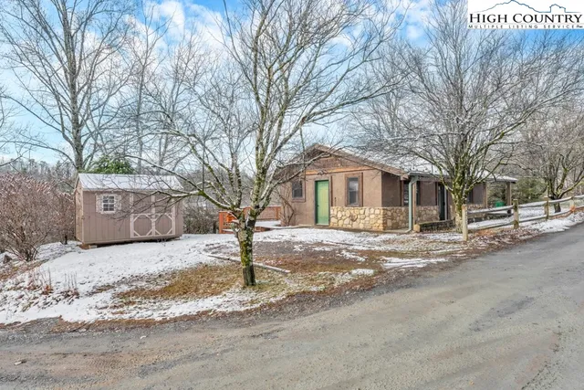 a front view of a house with a yard covered in snow