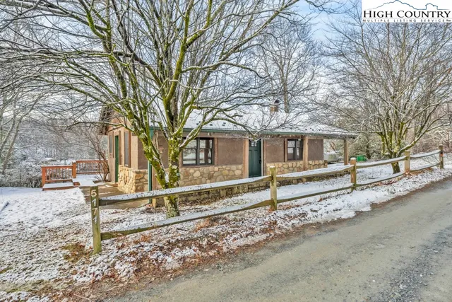a view of a house with a yard and a large tree