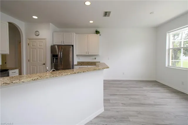 a view of kitchen with stainless steel appliances granite countertop cabinets and wooden floor