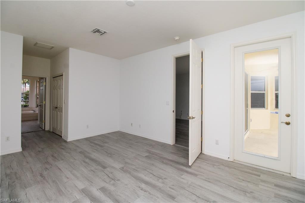 3927 Aurora Court Naples, FL 34116 - Photo 16 of 26 Empty room with light wood finished floors