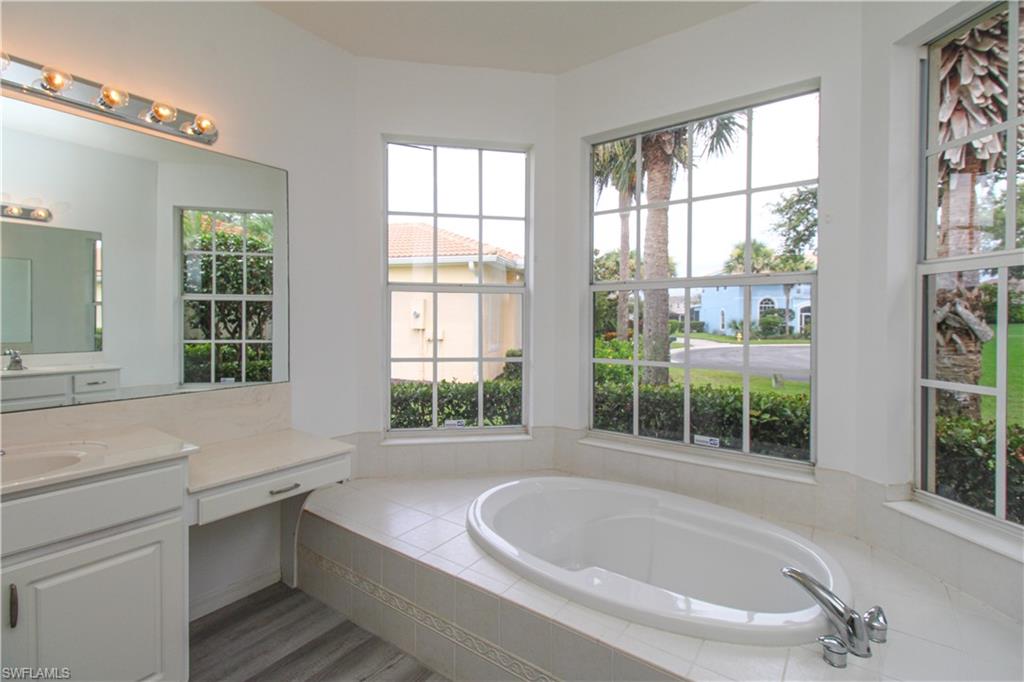 3927 Aurora Court Naples, FL 34116 - Photo 20 of 26 Full bath with vanity, a garden tub, and plenty of natural light