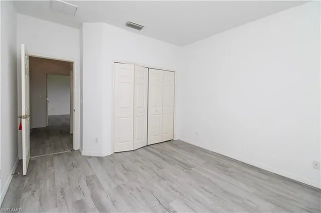an empty room with wooden floor and closet