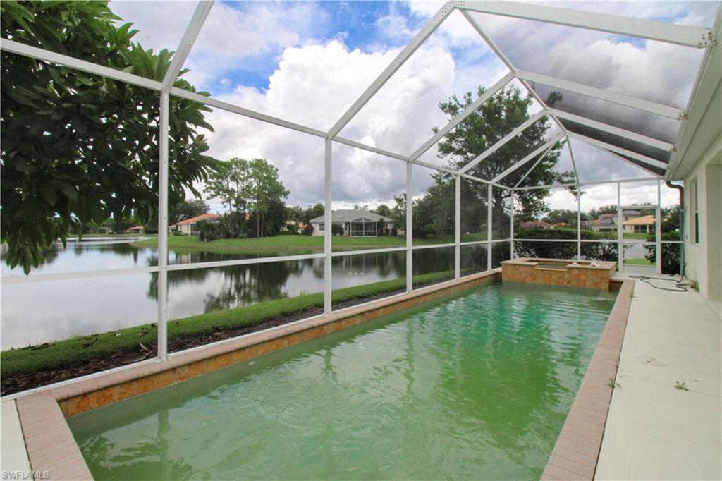 3927 Aurora Court Naples, FL 34116 - Photo 24 of 26 View of swimming pool with a sunroom, a lanai, a water view, a pool with connected hot tub, and a patio