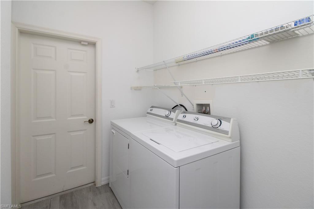 3927 Aurora Court Naples, FL 34116 - Photo 26 of 26 Washroom with independent washer and dryer and light wood-style floors