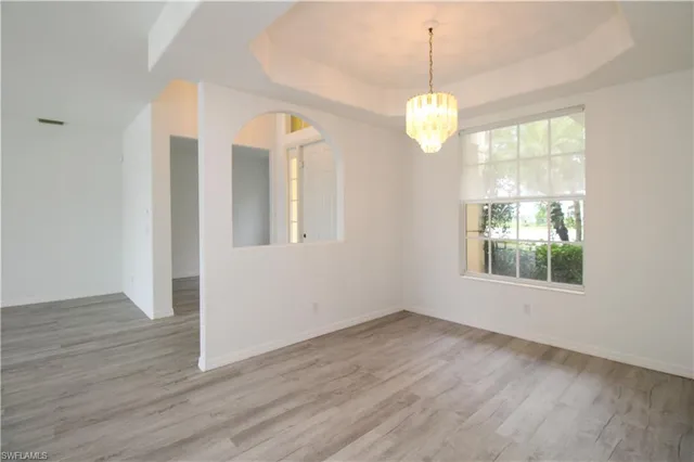 a view of an empty room with wooden floor and windows