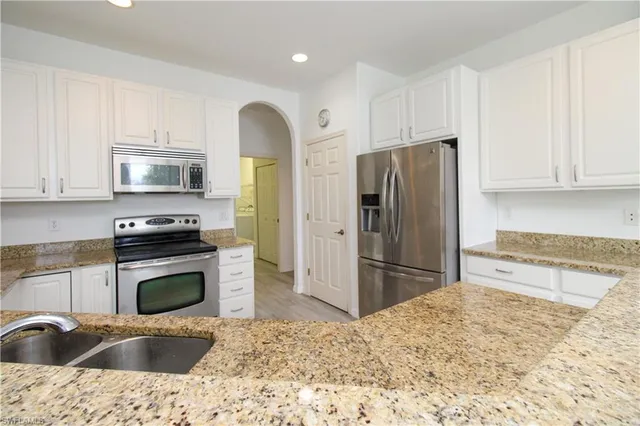 a kitchen with stainless steel appliances granite countertop a refrigerator sink and stove