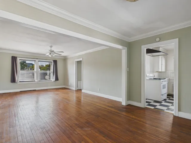 a view of livingroom with hardwood floor and a kitchen