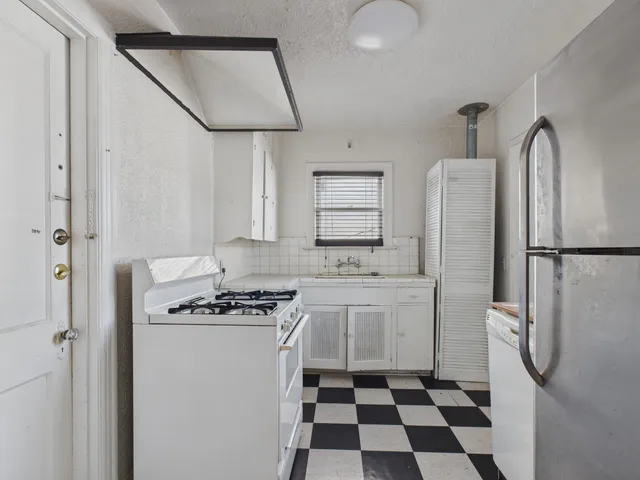 a kitchen with stainless steel appliances a refrigerator a stove a sink and a refrigerator