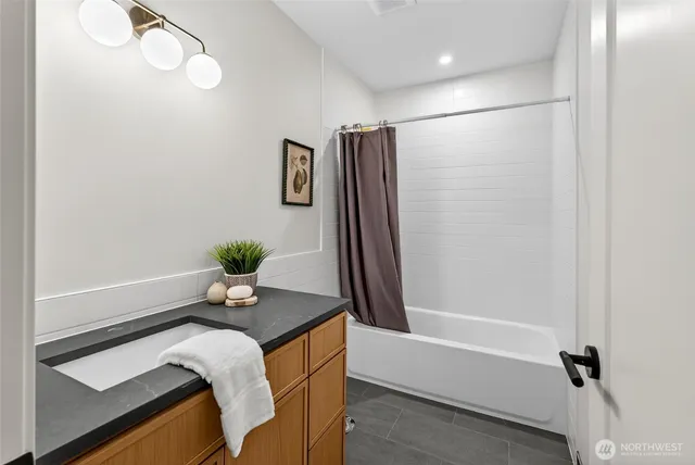 a bath room with a granite countertop sink and a mirror