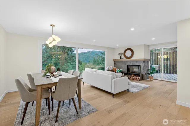 a living room with furniture a fireplace and a dining table with wooden floor