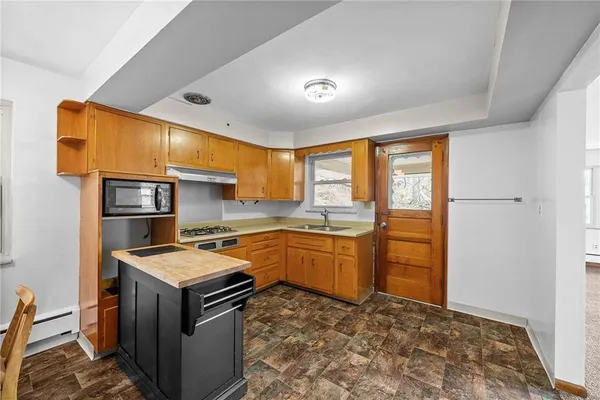 a kitchen that has a sink stainless steel appliances wooden floor and a window