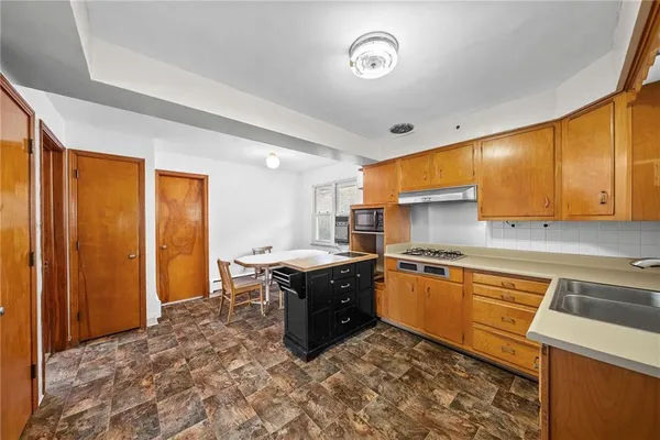 a kitchen with stainless steel appliances granite countertop a stove a sink and a refrigerator