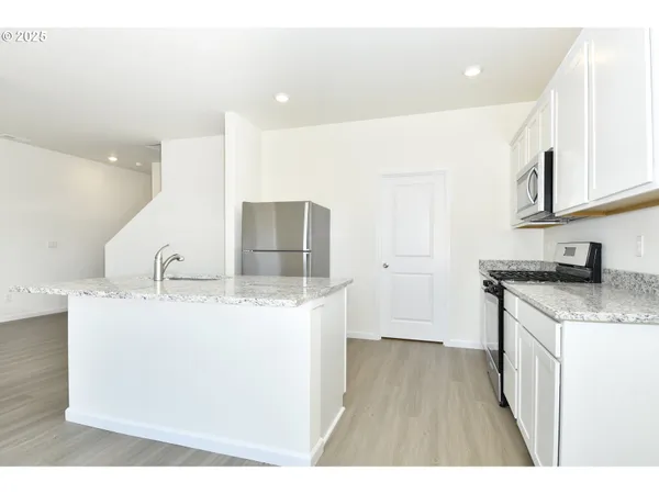 a kitchen with stainless steel appliances granite countertop a sink stove and cabinets