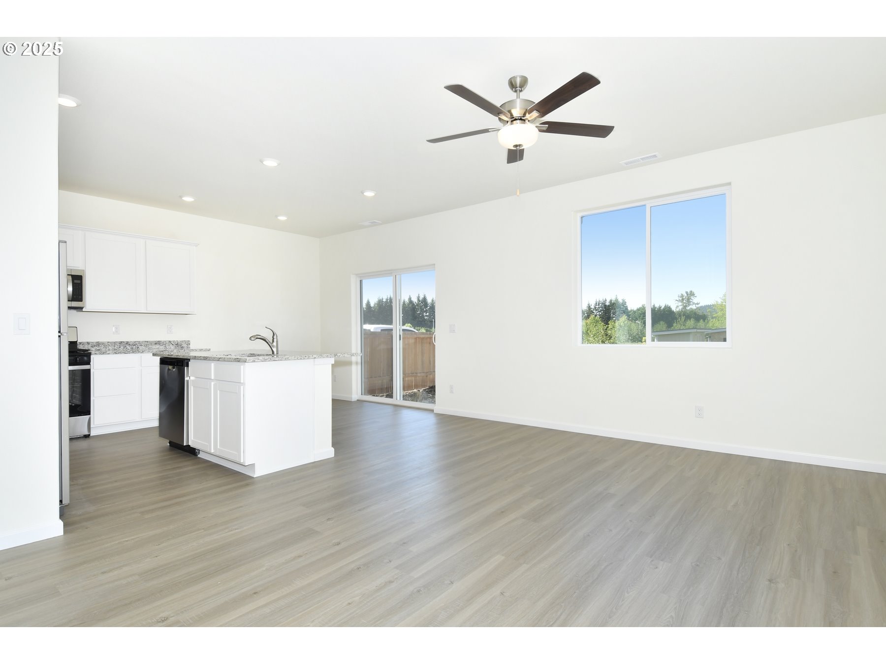 3990 Southwest Duniway Lane Gresham, OR 97080 - Photo 3 of 20 a view of a kitchen with wooden floor and a ceiling fan