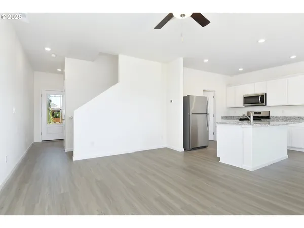 a view of kitchen with stainless steel appliances refrigerator stove microwave and cabinets