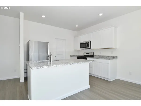 a kitchen with stainless steel appliances granite countertop a sink refrigerator and microwave